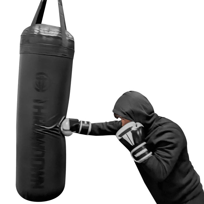 Training on a black Throwdown 4 ft heavy bag with black and white gloves.